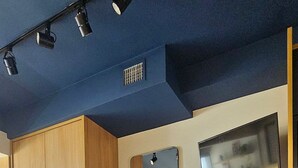 Ein modernes Interieur mit Holzboden, einer Bar mit Hockern und einem an der Wand befestigten Fernseher.