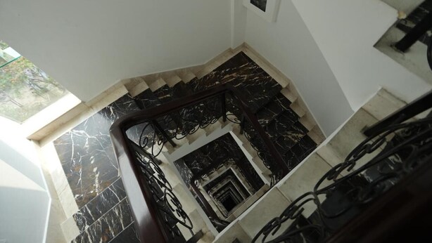 Eine Treppe mit schwarzen Metallgeländern und Marmorstufen.