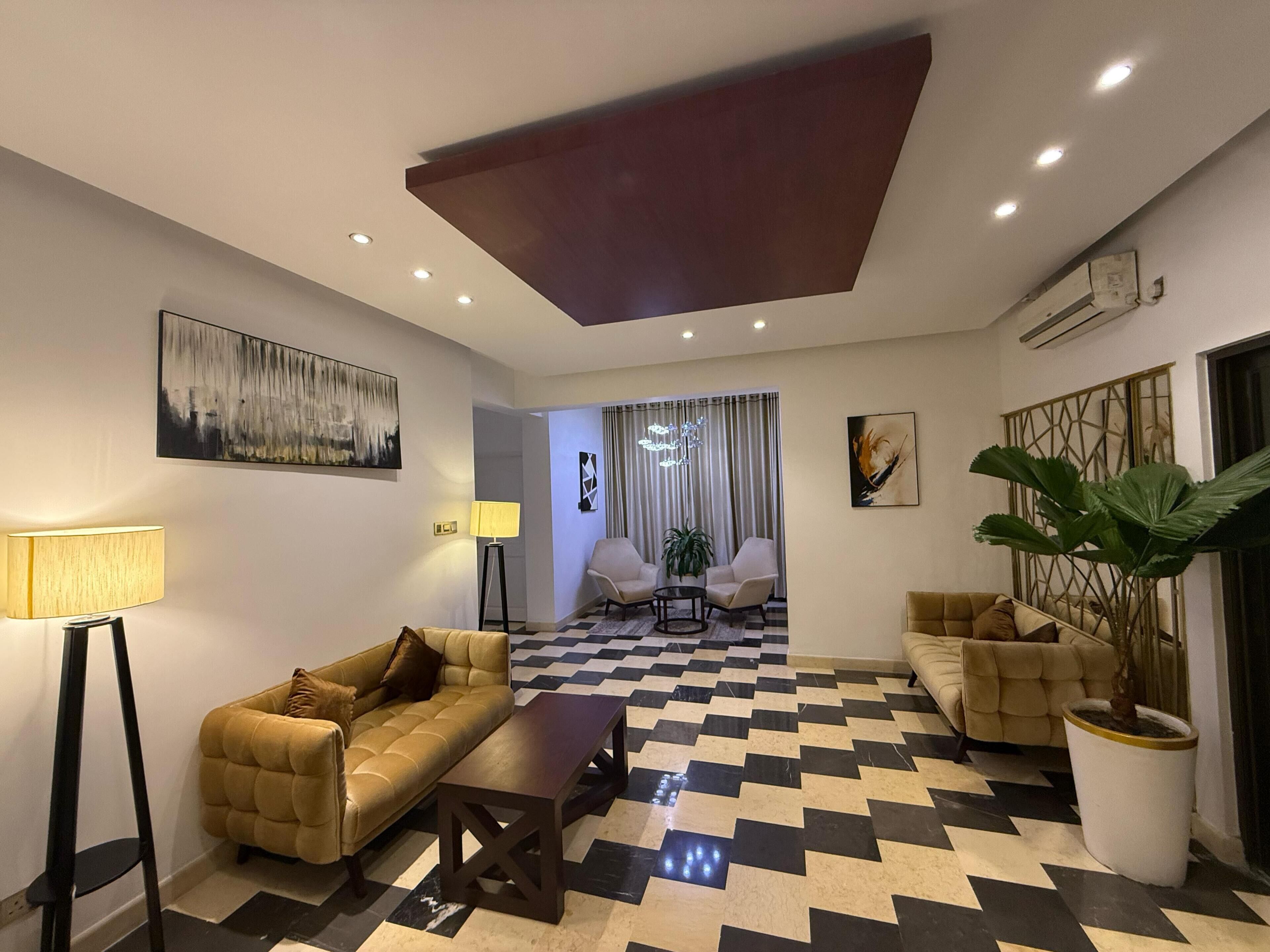 A modern living room with a checkered floor, two sofas, a coffee table, and a lamp.