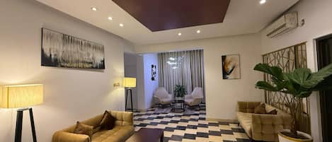 A modern living room with a checkered floor, two sofas, a coffee table, and a lamp.