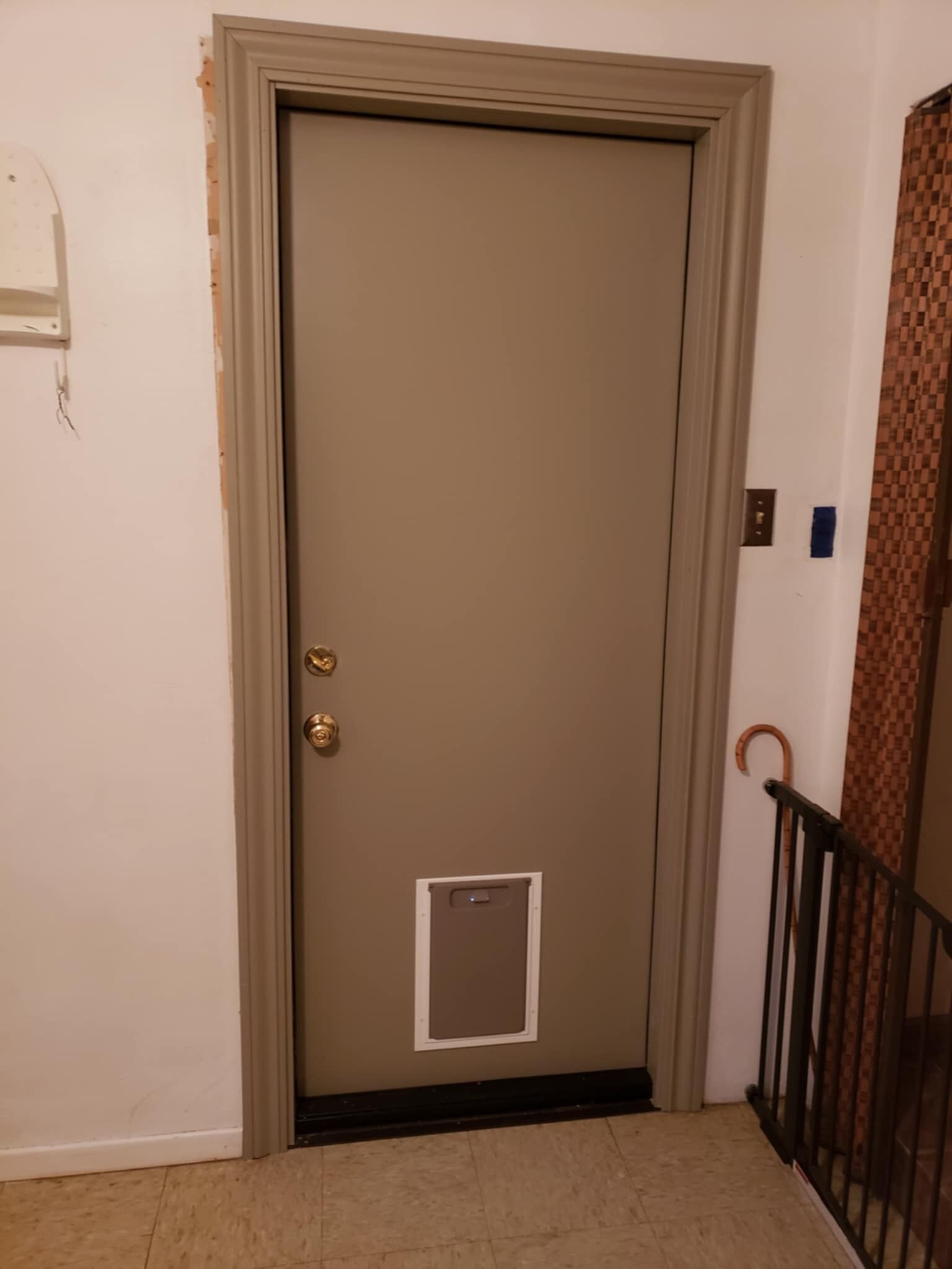 Una puerta cerrada con un ventanal pequeño, un picaporte metálico y un timbre.