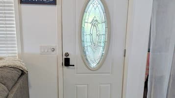 Une porte blanche avec un panneau de verre et une inscription au-dessus : « chez soi, quel bonheur ! »