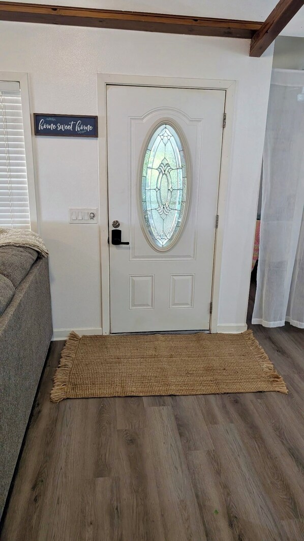 A white door with a glass panel and a sign above it that reads 'home sweet home.'