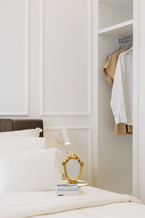 A neatly made bed with white linens, a bedside lamp, a gold-framed mirror, and a book on the nightstand. - The Harbour - Boutique sea view room in Dubrovnik (Dubrovnik)