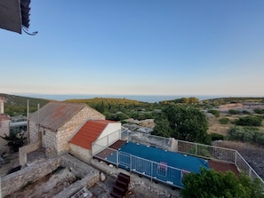 A view of a coastal area with a building featuring a blue roof and a stone structure.