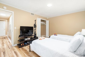 A hotel room with a television, a guitar, a bed, and a small table with video games. - Charming 3-bedroom townhome - Hot Springs Village - Convenient, near West Gate (Hot Springs)