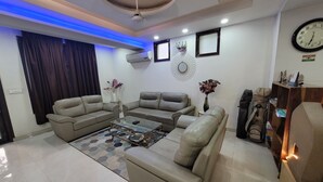 Uma sala de estar moderna com um sofá modular, uma mesa de centro e vasos decorativos.
