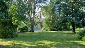 A well-maintained grassy area with trees and a body of water in the background.