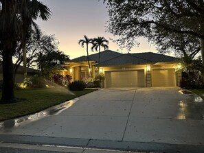 Ein Wohnhaus mit Garage, Auffahrt und gepflegtem Rasen.