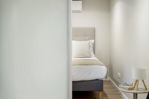 Ein Schlafzimmer mit Bett, Nachttisch und Lampe.