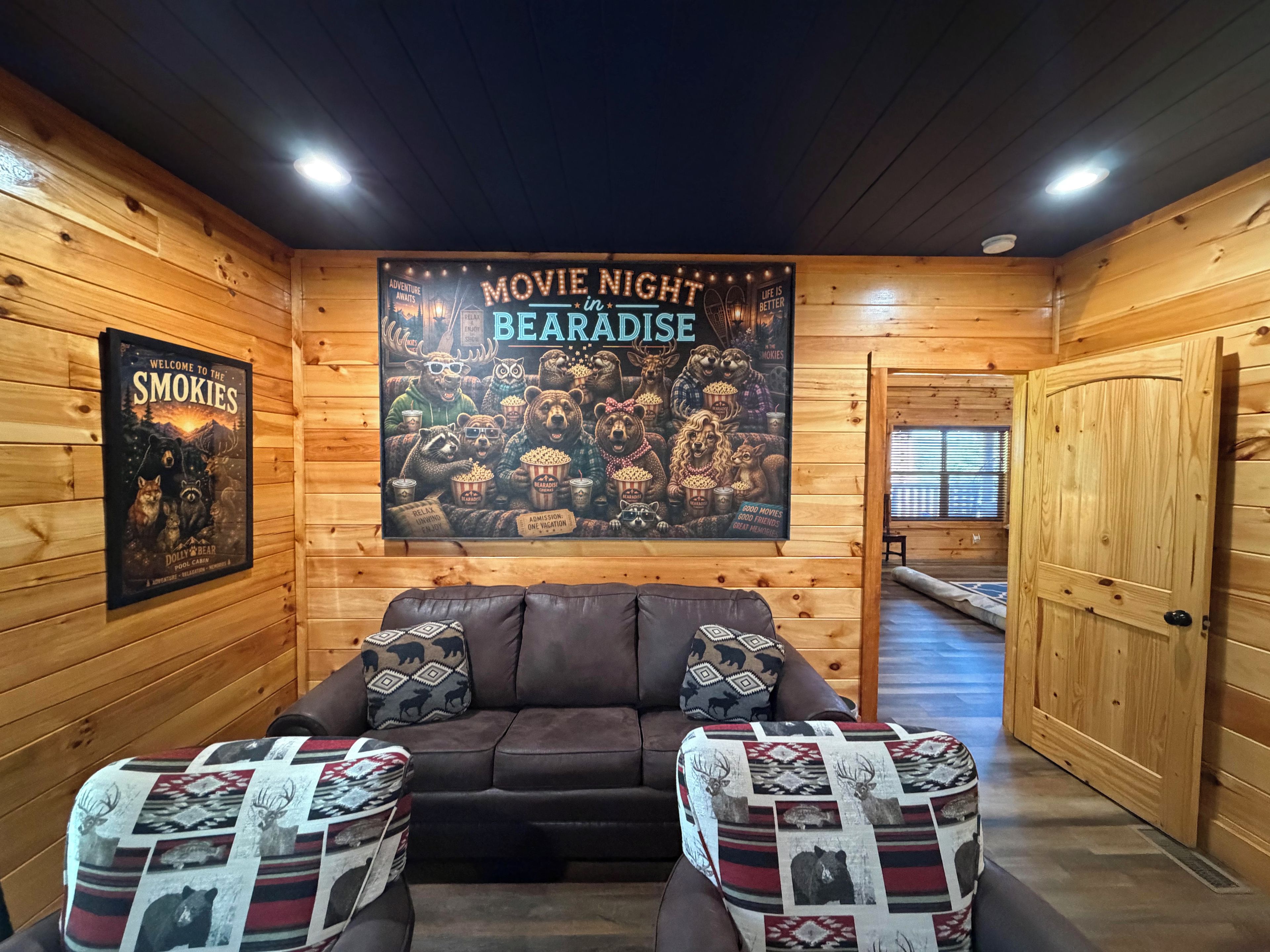 A cozy cabin interior with a movie night poster, a leather couch, and patterned cushions.
