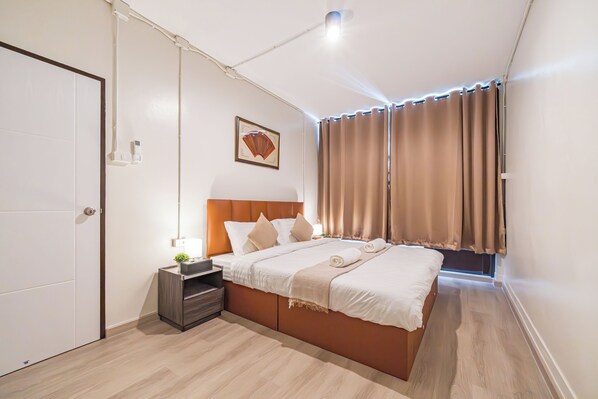 Ein Hotelzimmer mit Bett, Nachttisch und Wandleuchte.