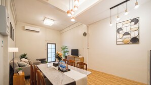 A modern dining area with a wooden table, chairs, and a decorative wall piece. - Siam Place Family House Near Khaosan 8 Guests (Bangkok)