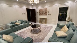 Ein geräumiges Wohnzimmer mit zwei Sofas, einem Couchtisch und einer Wanddekoration.