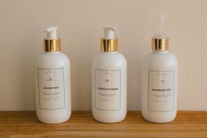 Three bottles of personal care products on a wooden surface.