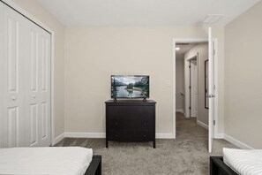 A bedroom with two beds, a dresser, and a television on a stand. - 5 BD/ 4 BA/ Storey Lake (4810 ML) (Kissimmee)