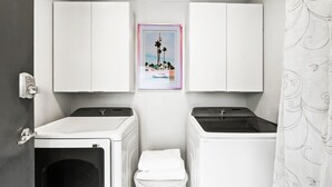 A laundry room with two washing machines, a drying rack, and a picture on the wall. - Beach Rd, 300ft to Beach Access & 500ft to Siesta Key Village, Studio (Siesta Key)
