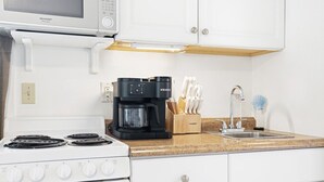 A kitchen with a stove, a coffee maker, a knife block, and a microwave. - Beach Rd, 300ft to Beach Access & 500ft to Siesta Key Village, Studio (Siesta Key)