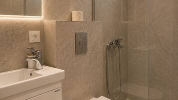 Appartement, balkon, uitzicht op tuin | Badkamer | Een douche, handdoeken, zeep, toiletpapier