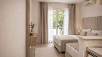 A modern bedroom with a bed, bedside table, and a view of greenery outside.