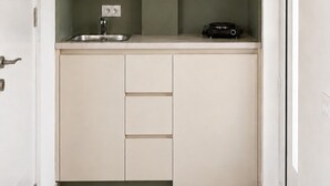 A compact kitchenette with a built-in sink, a small countertop, and a cabinet with drawers. - Guest House Fjola (Donji Štoj)