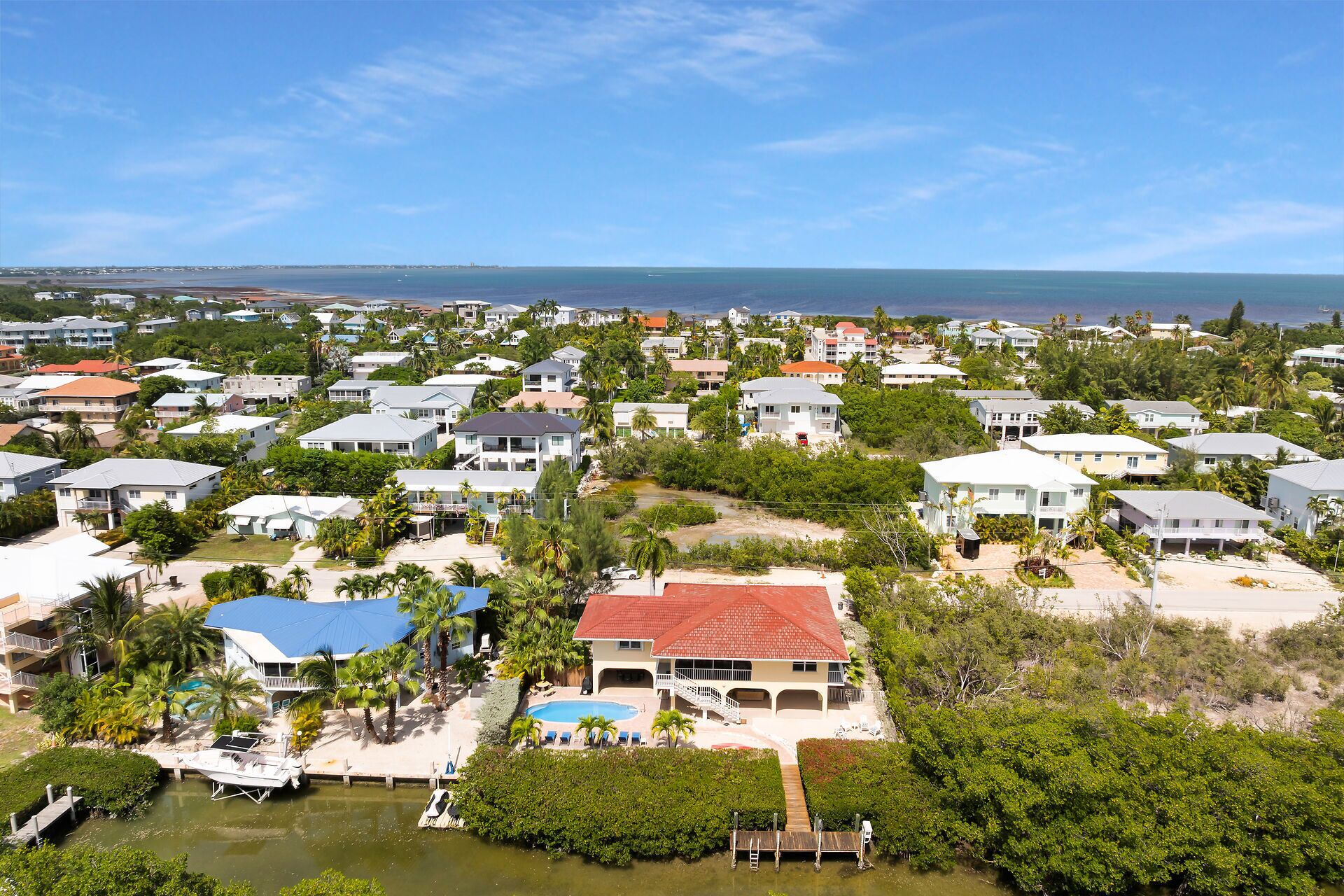A coastal residential area with houses, a swimming pool, and a dock.
