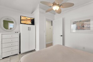 A bedroom with a bed, a wardrobe, a ceiling fan, a television, and a framed picture on the wall. - Salty Skies : 4-bedroom - Pool - Dock - walking distance from Sombrero Beach (Marathon)