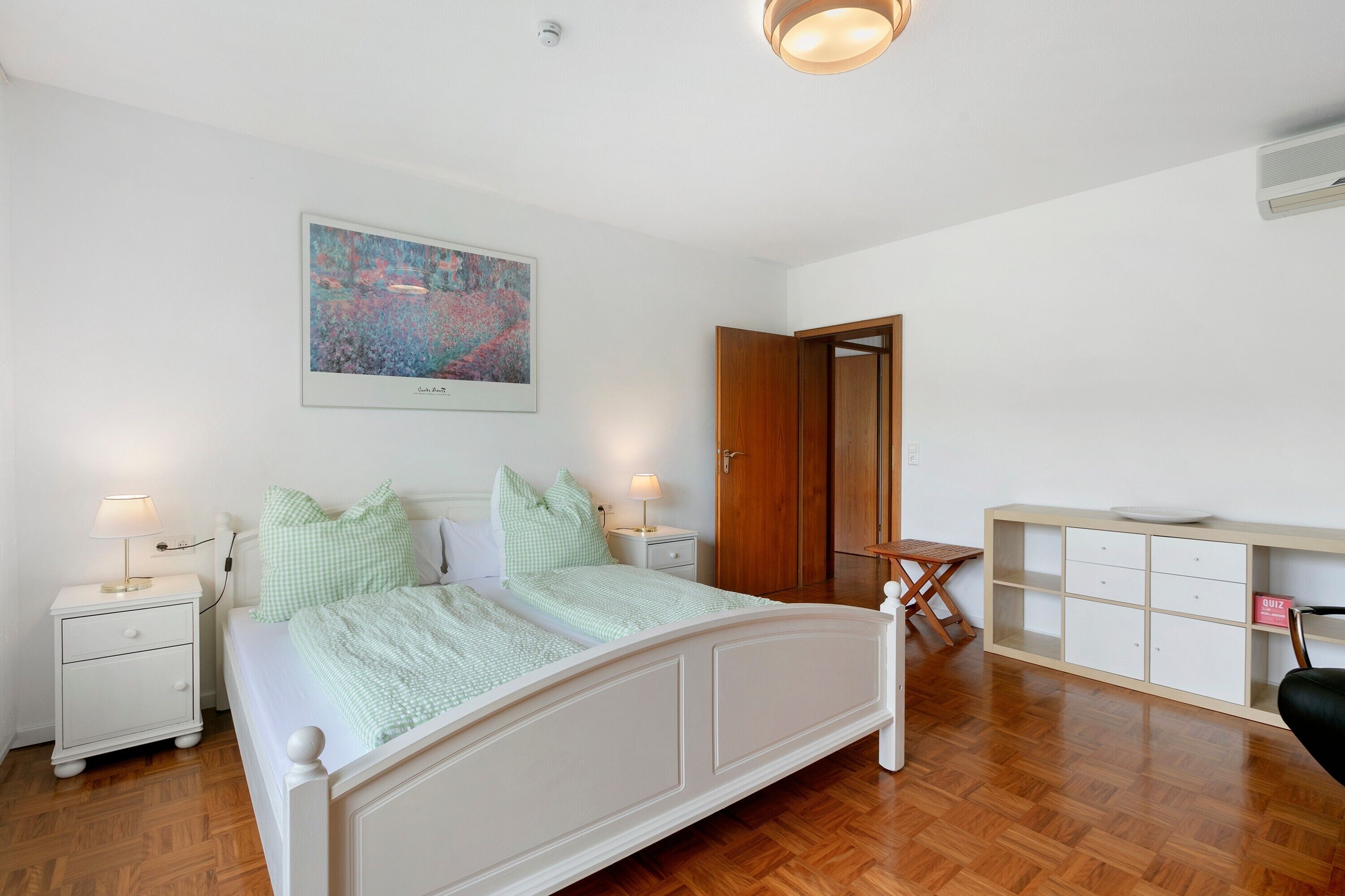 Ein Schlafzimmer mit einem Bett, Nachttischen, einem Schreibtisch und einem Stuhl.