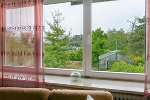 A window with a view of a greenhouse and a clear sky.