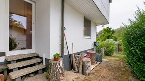 A house with a stone staircase, a potted plant, and a wooden bench outside. - Quiet Riverside Wallbach Apartment with Terrace, AC, Washer, and Rhine View (Bad Säckingen)
