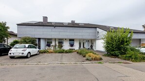 A modern two-story house with a paved driveway and a white car parked in the driveway. - Quiet Riverside Wallbach Apartment with Terrace, AC, Washer, and Rhine View (Bad Säckingen)