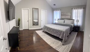 A bedroom with a bed, a dresser, a TV, and a large mirror. - Awesome 3-bedroom house with AC in delightful Chattanooga (Chattanooga)