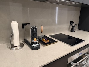 A kitchen with a coffee machine, a paper towel dispenser, a tablet, and a coffee grinder. - 1-bedroom studio in adorable Miami with AC and fitness room (Miami)