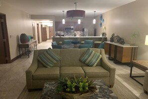 A living room with a sofa, a coffee table with plants, and a kitchen in the background. - Outstanding apartment at Dawn Beach Club, JW Marriott Resort, Beach and Spa (oyster pond)