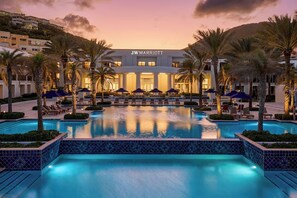 A JW Marriott hotel with a swimming pool, palm trees, and lounge chairs. - Outstanding apartment at Dawn Beach Club, JW Marriott Resort, Beach and Spa (oyster pond)