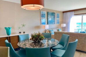 Un comedor moderno con una mesa redonda, sillas color turquesa y un centro de mesa decorativo.