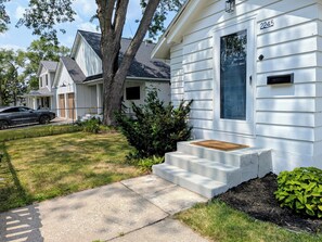 A residential house with a front porch, a mailbox, and a driveway.