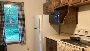A kitchen with a refrigerator, microwave, stove, and a window with curtains. - Vintage 2-bedroom+ cabin/summerhome; 5 minute walk to Lake beach (White Bear Lake)