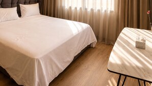 A hotel room with a large bed, a bedside table, a headboard, and a window with curtains. - Exclusive apartment with stunning panoramic sea views (Tanger)