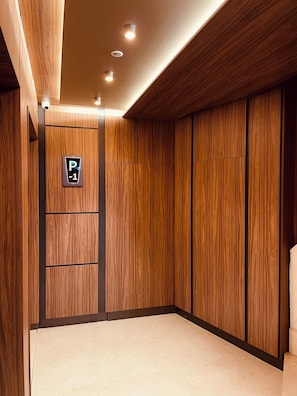 Un ascenseur moderne avec des finitions en bois et un panneau indiquant le niveau du parking, P-1.