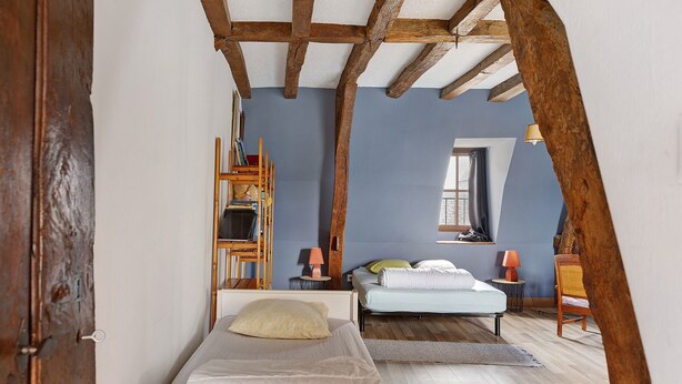 Quarto com cama, escrivaninha e cadeira.