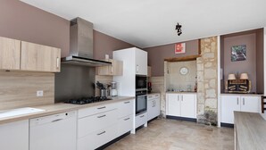 Uma cozinha moderna com armários brancos, uma lava-louças Bosch, um fogão Bosch e um forno Siemens.