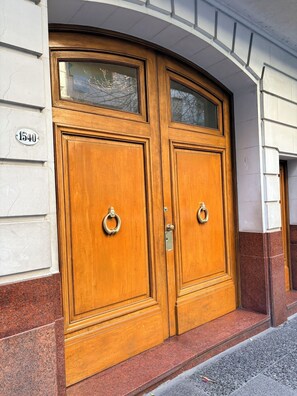 A double wooden door with a glass panel and a metal ring handle. - Spacious Recoleta apartment in desired location - French style & Modern Comfort (Buenos Aires)