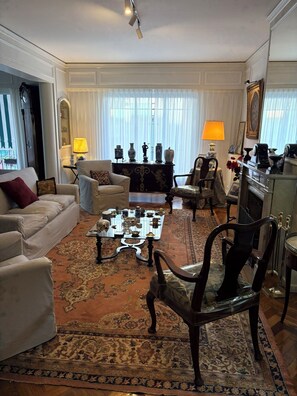 A well-furnished living room with a sofa, armchairs, a coffee table, and a fireplace. - Spacious Recoleta apartment in desired location - French style & Modern Comfort (Buenos Aires)