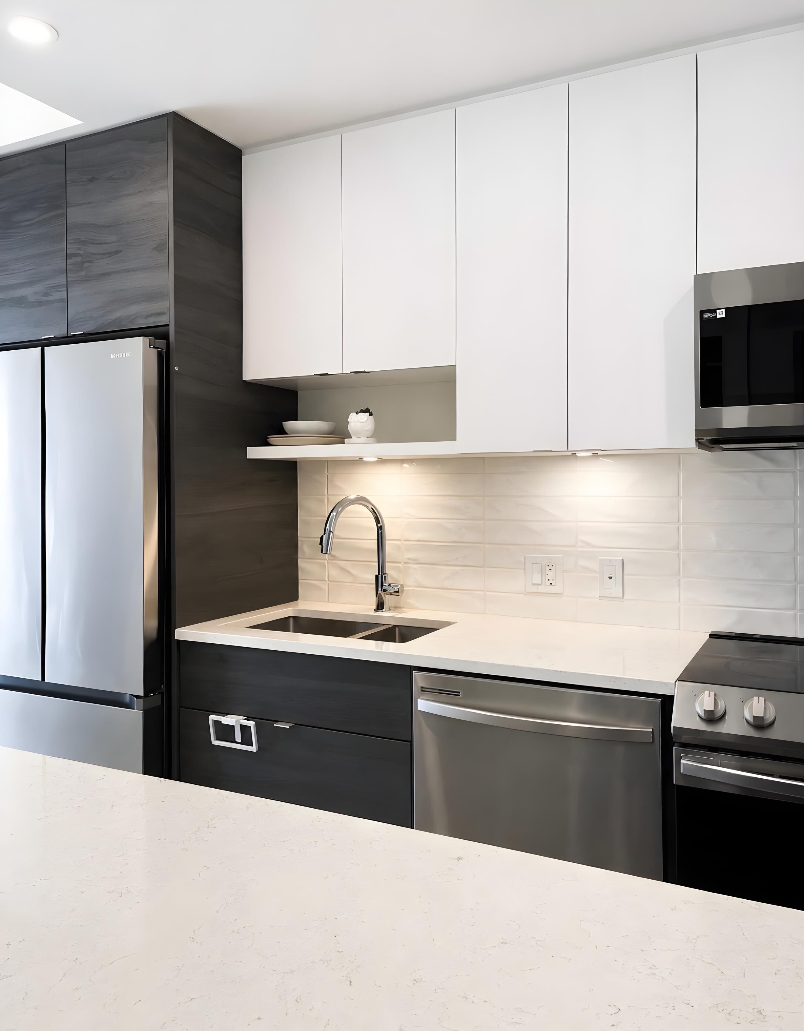 A modern kitchen with stainless steel appliances, a dishwasher, and a microwave.