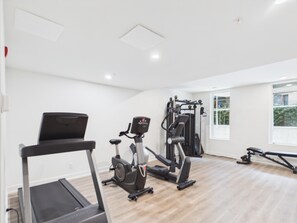 A gym with a treadmill, elliptical, and weight machines. - Modern Waterfront Condo with Harbour Views (Victoria Central British Columbia Provincial Government)