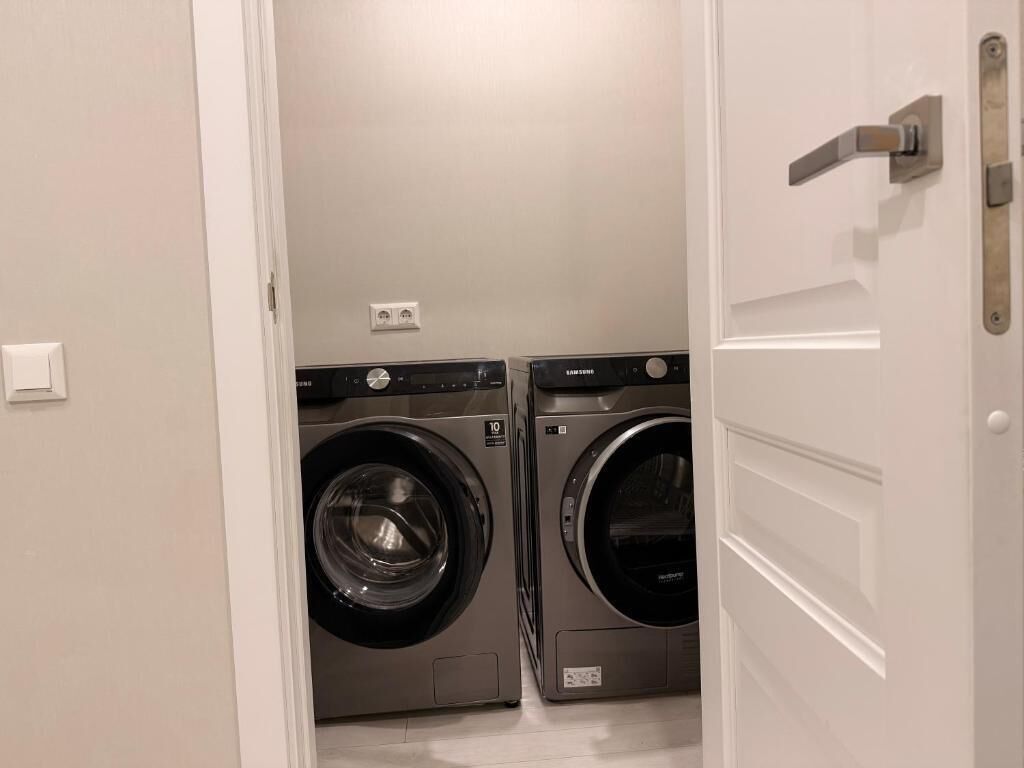 Une buanderie équipée de deux machines à laver à chargement frontal et d’un sèche-linge.