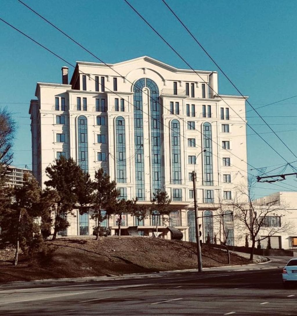 Un edificio a più piani con una finestra ad arco centrale e una facciata simmetrica.
