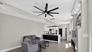 Un soggiorno moderno con un divano grigio, un tavolino da caffè e una ventola a soffitto.