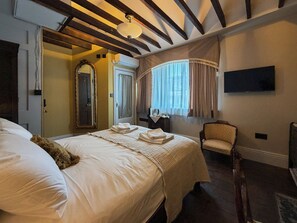 A hotel room with a large bed, a chair, a television, and a window with curtains. - 41 Whitfield Street (London)